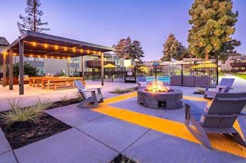 Evening image of fire pit with seating near pool